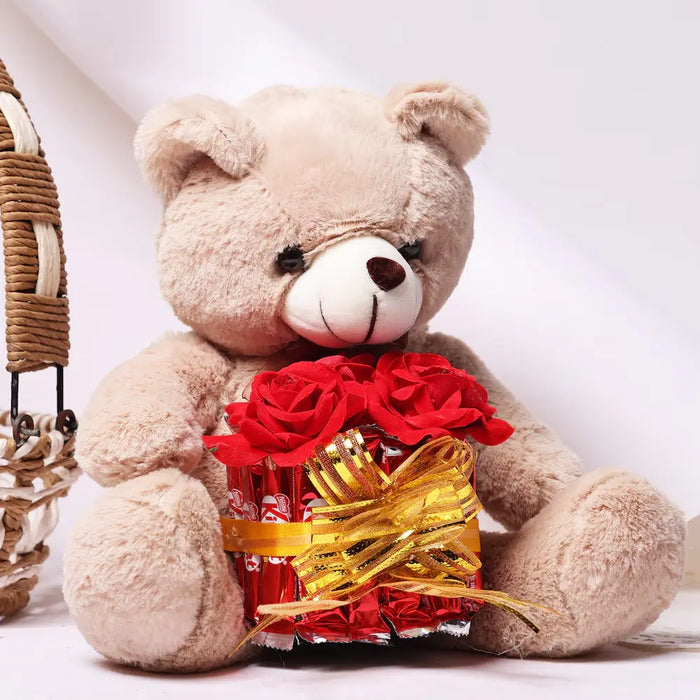 Plush teddy bear with red roses and chocolates in a gift basket
