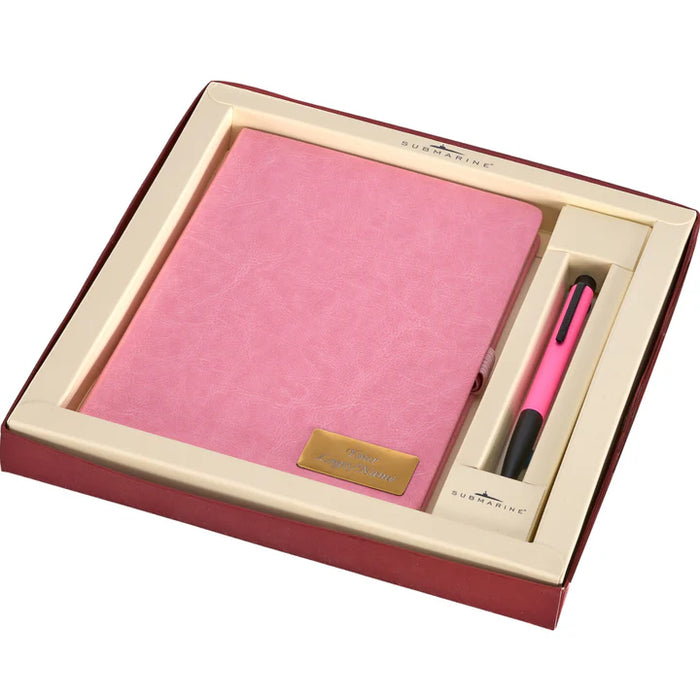 Pink notebook and pen set in a decorative box with a visible brand label.