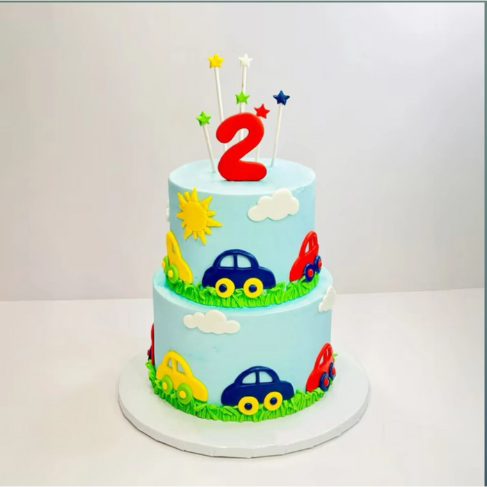 Colorful 2nd birthday car themed cake with stars, cars, and clouds decoration
