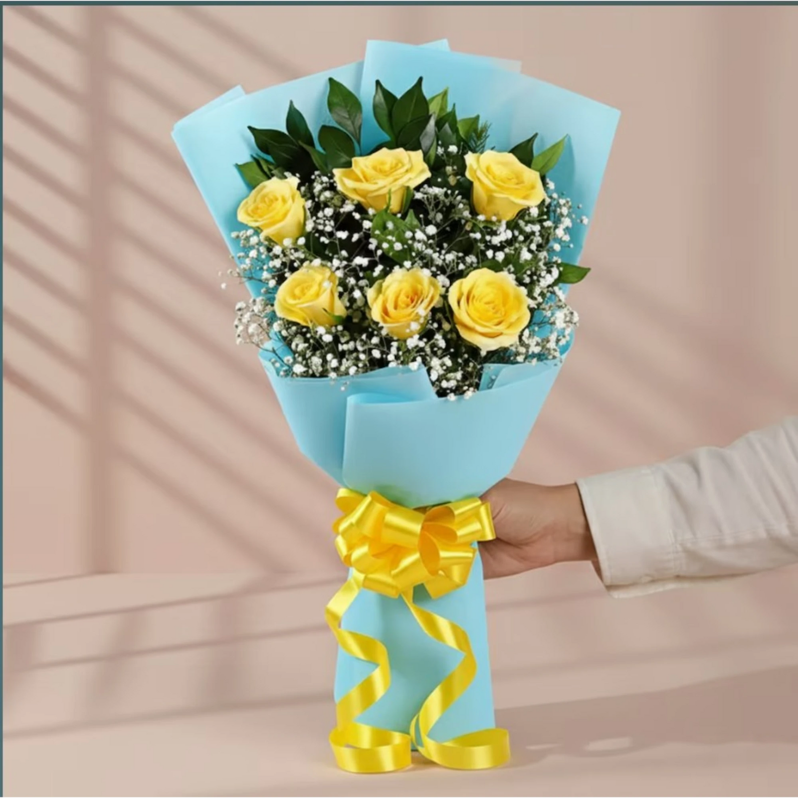 Yellow roses bouquet with green leaves and baby's breath wrapped in blue paper