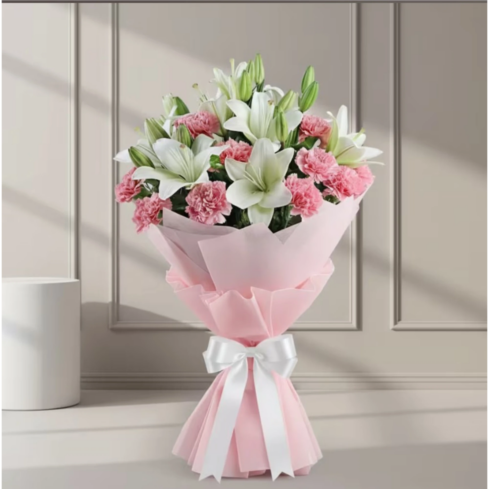Bouquet of white lilies and pink carnations wrapped in pink paper