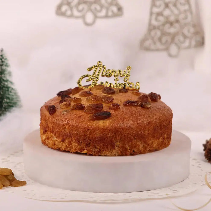 Raisin Dry Cake - Christmas Special 300gm round cake topped with raisins and a golden 'Merry Christmas' topper, ideal for festive gifting.
