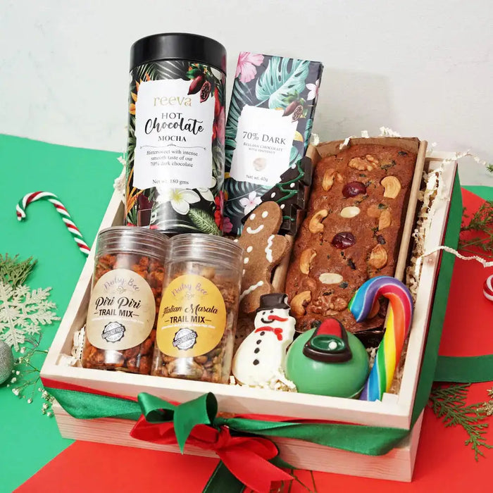 Christmas Gift Hamper - Treat Treasury featuring hot chocolate, dark chocolate bar, gingerbread, tea cake, trail mix, and festive cookies.