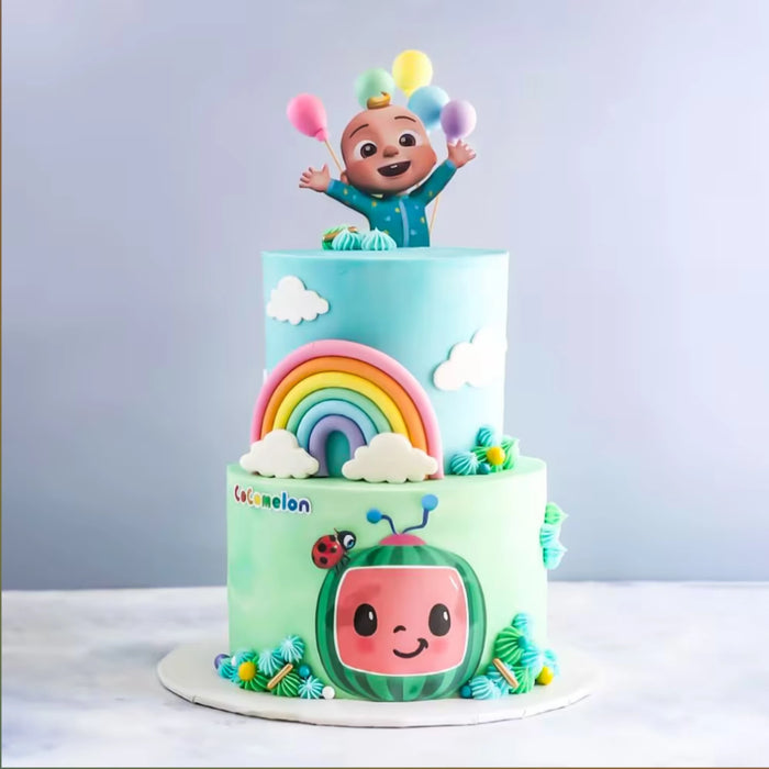 Colorful rainbow-themed cake with cute watermelon face and rainbow decorations for kids' celebration