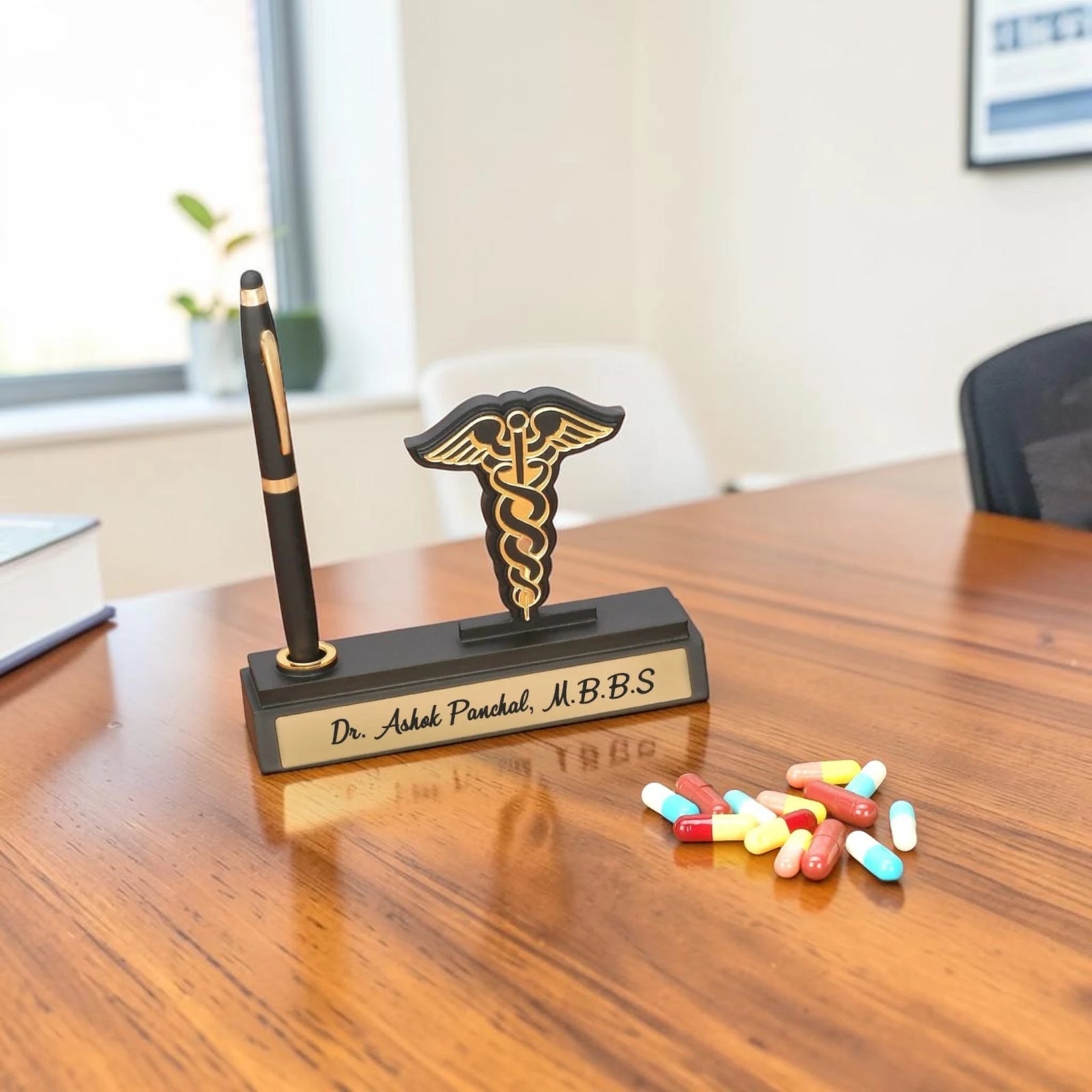 Pen holder with caduceus symbol on a desk with pills and a blurred office background