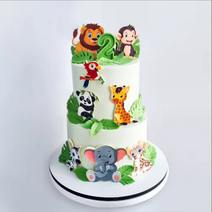 Jungle theme cake with animal toppers and green leaves