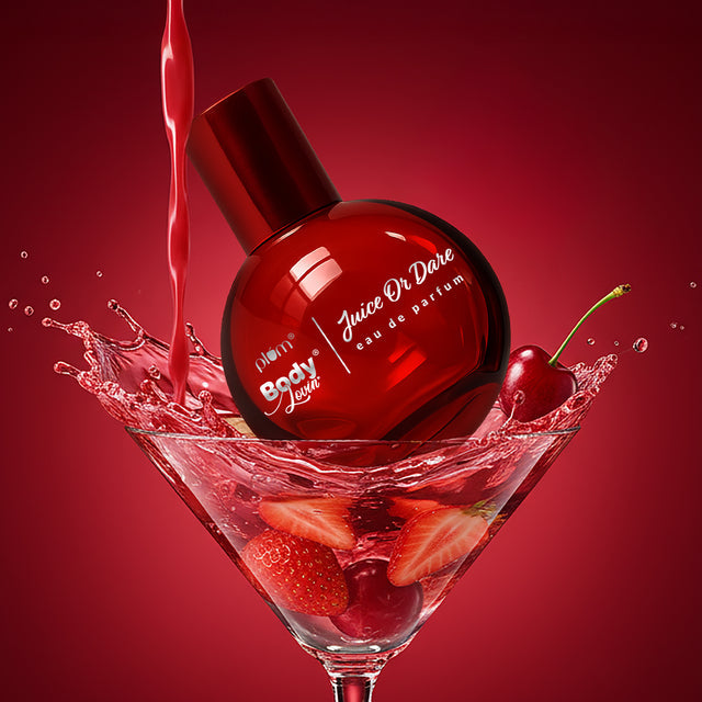 Juice or Dare Eau de Parfum 50ml bottle splashing into a martini glass with strawberries and cherries, highlighting its fruity essence.