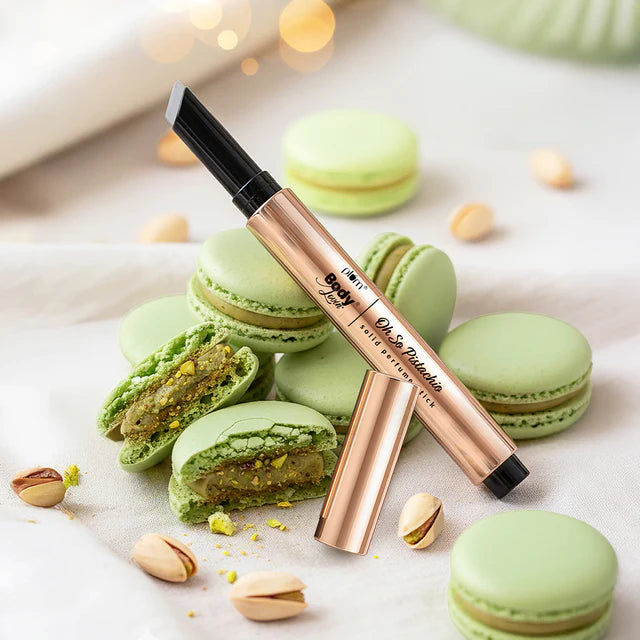 Oh So Pistachio Solid Perfume Stick gift set with pistachio macarons, showcasing a sleek rose gold stick ideal for travel and daily use.