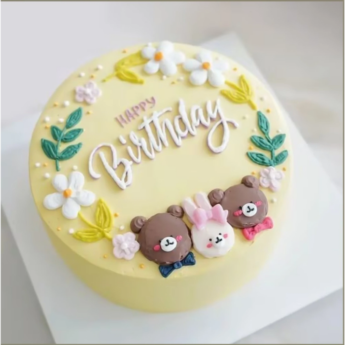 Yellow cake with floral decorations and teddy bear toppers for celebration