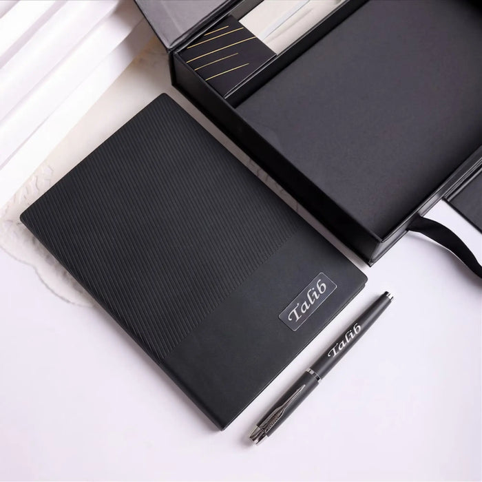 Black notebook and pen set with 'Talib' branding on a white surface