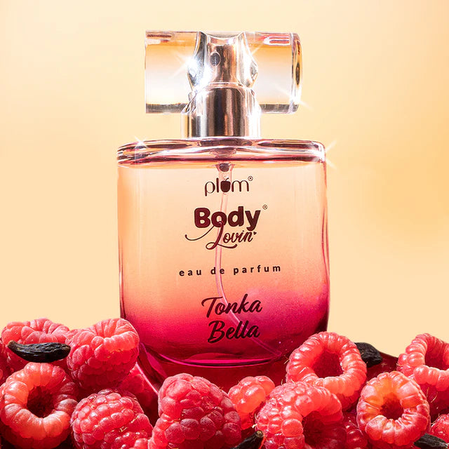 Tonka Bella Eau De Parfum 50ml bottle with pink ombré design surrounded by fresh raspberries, highlighting its fruity vanilla caramel scent.